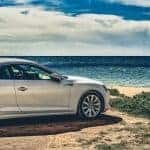 Auto steht am Strand mit Meer im Hintergrund