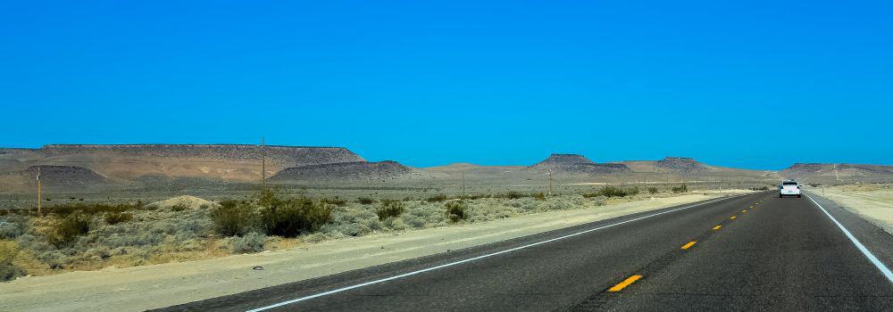 Straße in den USA mit Auto am Horizont