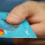 Kreditkarte wird von Hand überreicht für die Bezahlung der Kaution