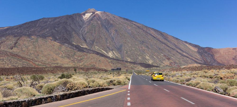 Ein Mietwagen von TUI Cars fährt in Teneriffa auf der Straße in Richtung eines Berges