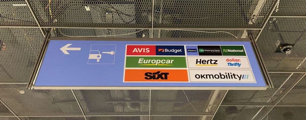 Beschilderungen am Flughafen zu verschiedenen Autovermietungen mit Shuttle Service