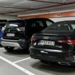 Mehrere Mietwagen verschiedener Hersteller in einer Tiefgarage auf Sixt-Parkplätzen, darunter ein Opel im Hintergrund.